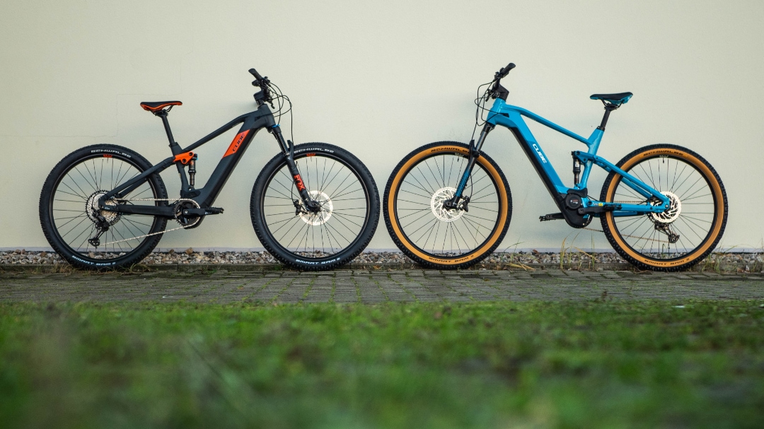 Zwei Cube Stereo Hybrid 120 E-Bikes, Modell 2021, nebeneinander aufgestellt.