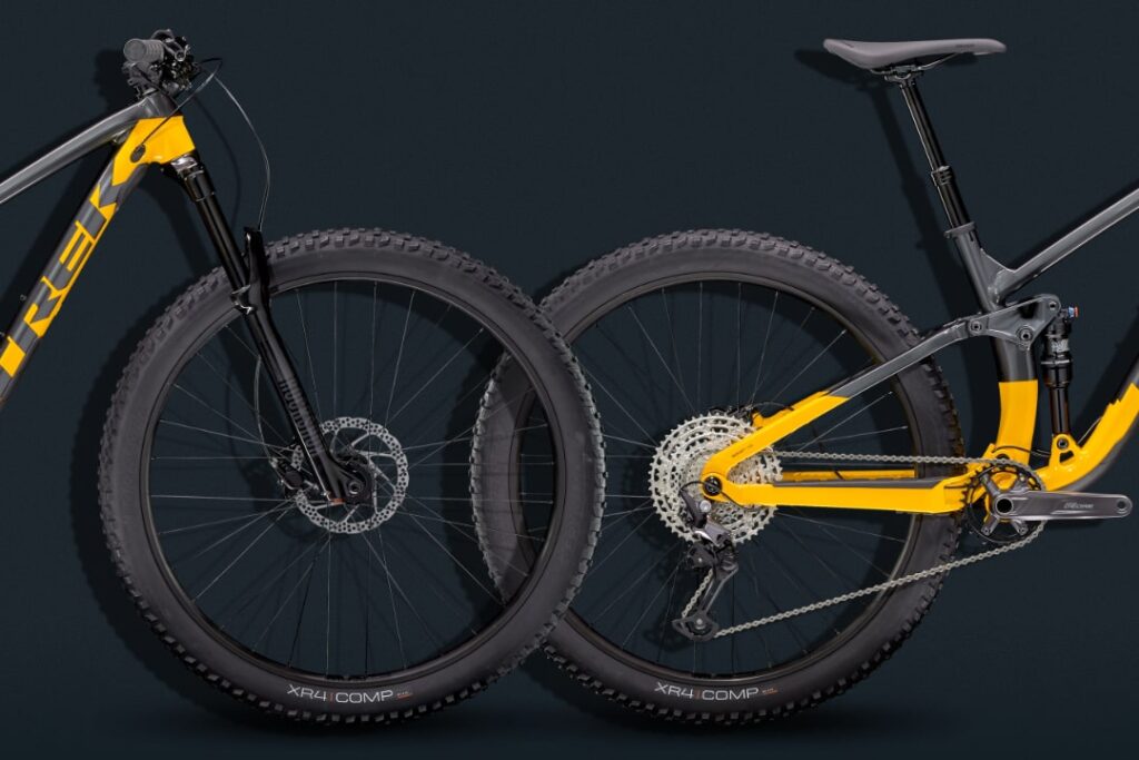 Hardtail und Fully Mountainbike im Vergleich, gelb-schwarze Rahmen, Fokus auf Federung und Reifen.