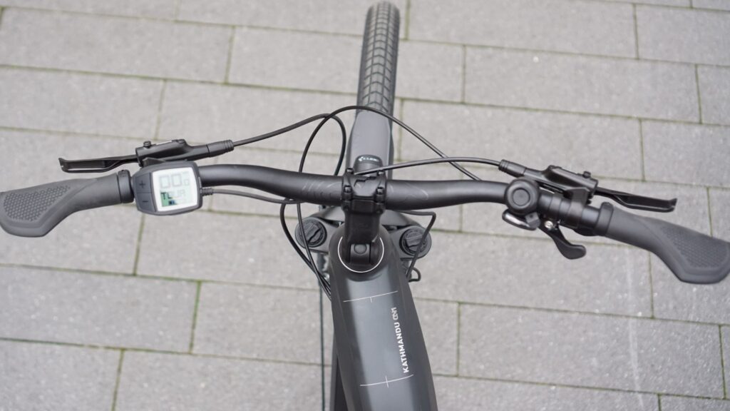 Cube Kathmandu Hybrid ONE 625 2022 Cockpit mit Display und Lenkeransicht auf grauem Pflasterhintergrund.