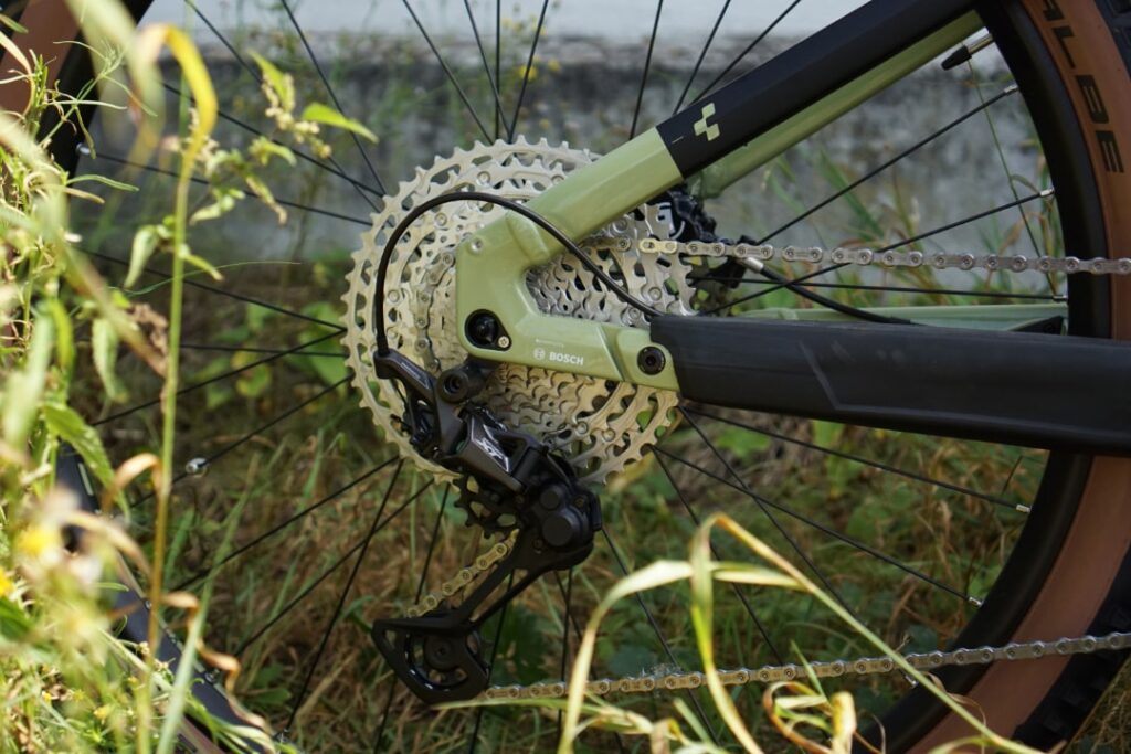 Shimano Deore XT Schaltwerk am Cube Stereo Hybrid 120 Race 625 2022, Detailansicht im Grünen.