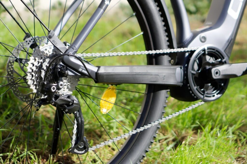 Cube E-Bike Hinterrad und Antrieb im Detail auf Gras, Shimano Alivio Schaltung.