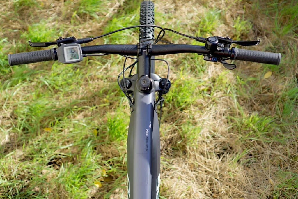 Cockpitansicht des Cube Reaction Hybrid Performance 500 Allroad mit Bosch-Display auf grasbewachsenem Untergrund.
