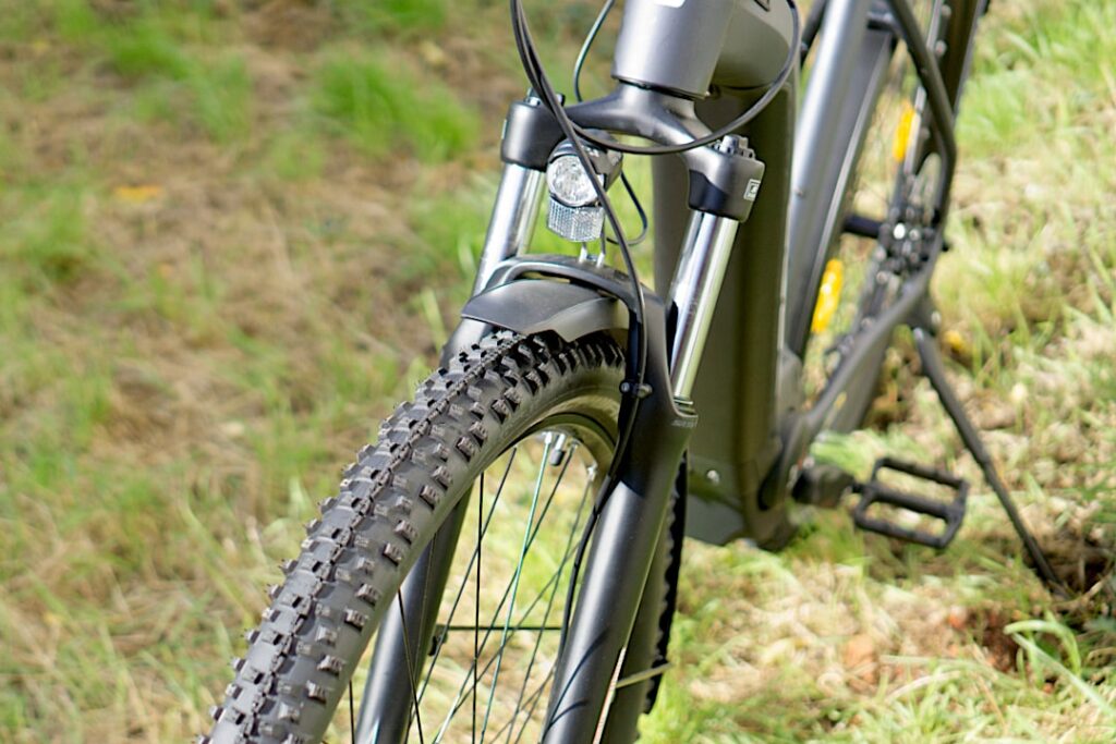 Cube Reaction Hybrid Performance 500 Allroad Vorderrad und Gabel auf Waldweg, robustes Design für Offroad-Abenteuer.