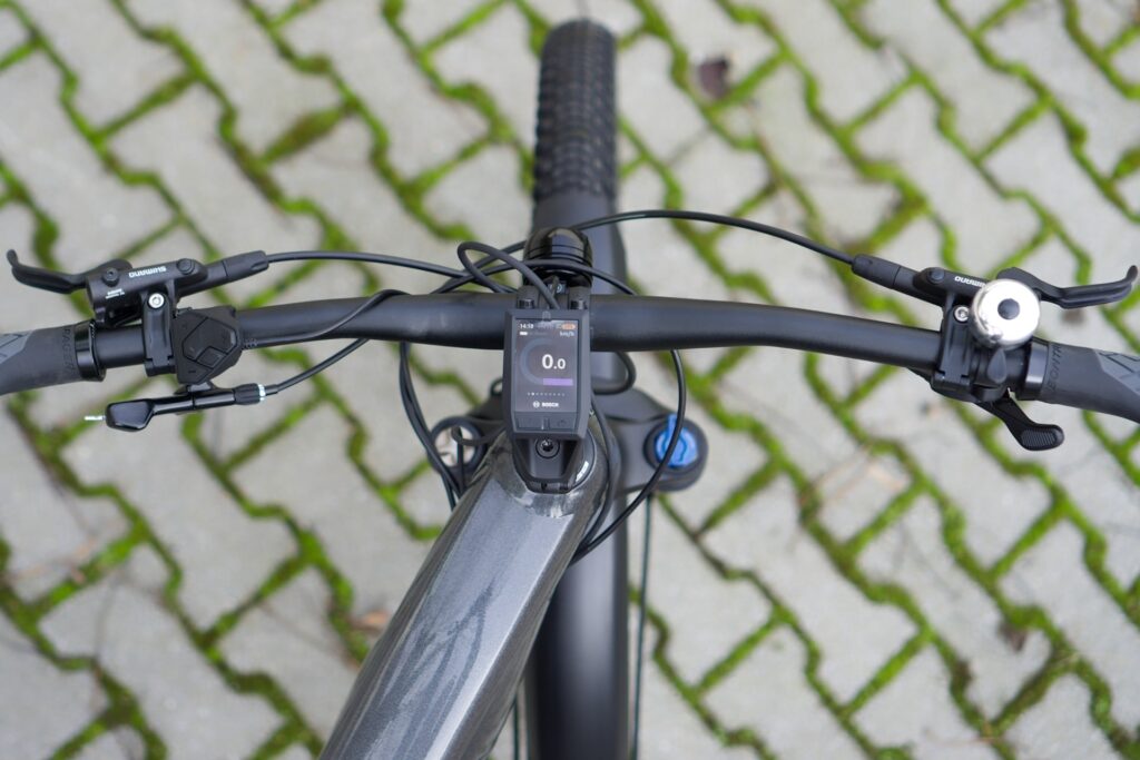 Trek Powerfly 7 Cockpit mit Bosch-Display und Shimano-Bremsen auf gepflastertem Untergrund.