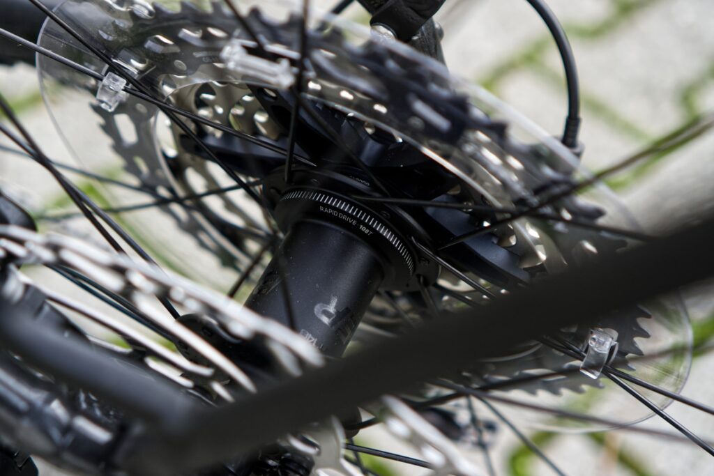 Nahaufnahme eines Fahrradnabenantriebs mit Speichen und Bremsscheibe, Fokus auf Trek Powerfly Ausstattung.