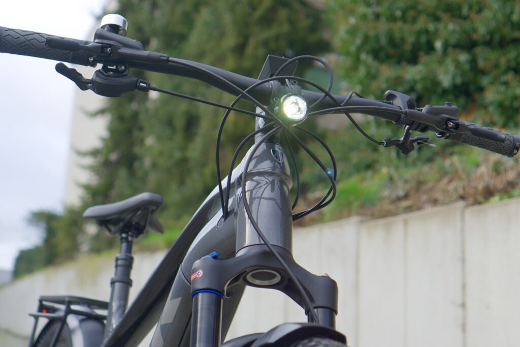Trek Powerfly 7 2022 Nahaufnahme, zeigt Lenker und Scheinwerfer, ideal für Testberichte und Vergleiche von E-Mountainbikes.