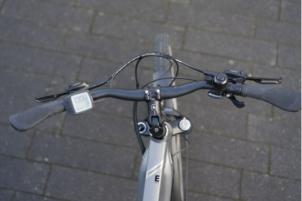 Cockpit des Bergamont E-Horizon FS Expert 2022 mit Display und Bedienelementen auf grauem Pflaster.