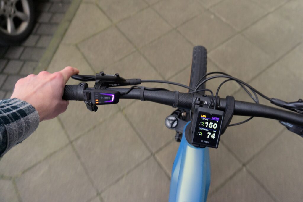 Cube Reaction Hybrid SL 750 2022 Lenkeransicht mit Bosch-Display während der Testfahrt auf grauem Pflaster.