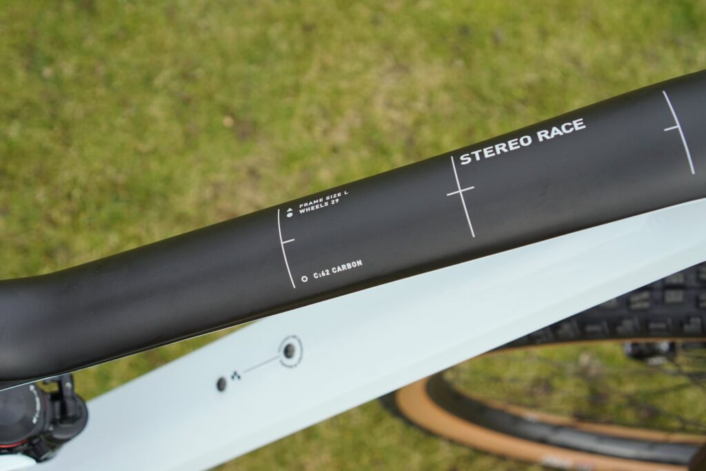 Cube Stereo 150 C:62 Race 2022 Rahmen aus C:62 Carbon, Größe L, mit 29-Zoll-Rädern, auf grünem Hintergrund.