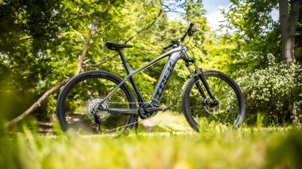 Trek Powerfly 4 2022 E-Mountainbike im Grünen, robustes Design, ideal für Offroad-Abenteuer.