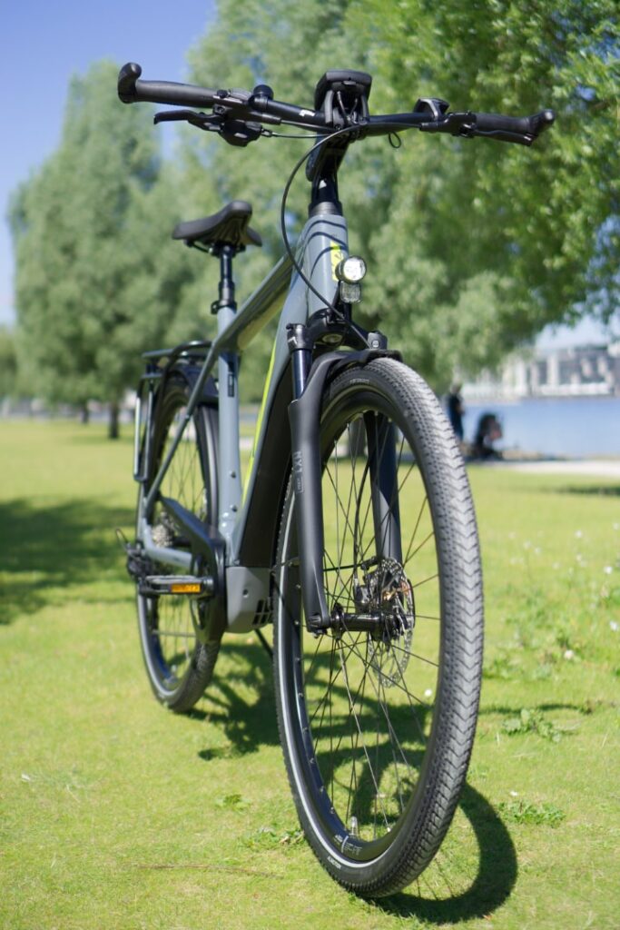 KTM Macina Sport Pro 2022 auf grünem Rasen, Fokus auf Vorderansicht und Details des Rahmens und der Reifen.