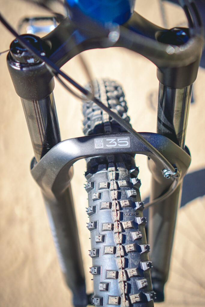 Nahaufnahme der Federgabel und des Reifens eines Mountainbikes, ideal für Geländetests und robuste Fahrten.