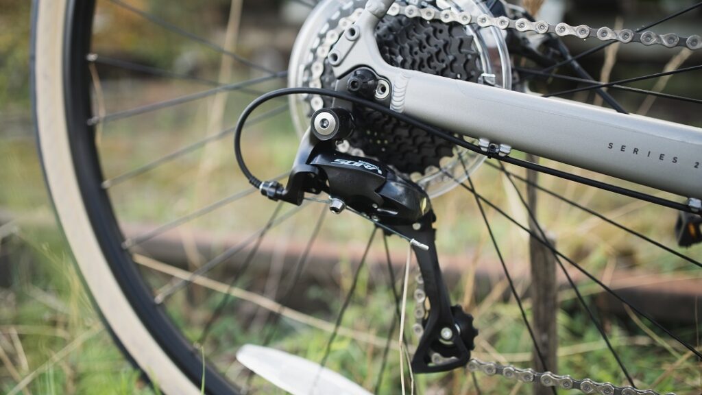 Schaltwerk des Marin Lombard 1 2023, Nahaufnahme mit Fokus auf Kettenschaltung und Hinterrad im Freien.