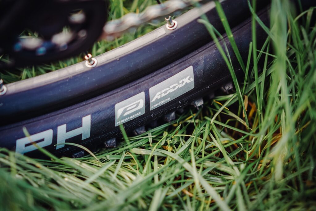 Cube Reaction PRO 2023 Reifen im Gras, zeigt Addix Performance Compound für optimale Geländetauglichkeit.