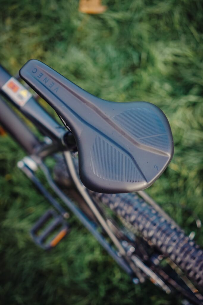 Cube Reaction PRO 2023 Sattel in Nahaufnahme, zeigt Details und Design auf grünem Hintergrund.