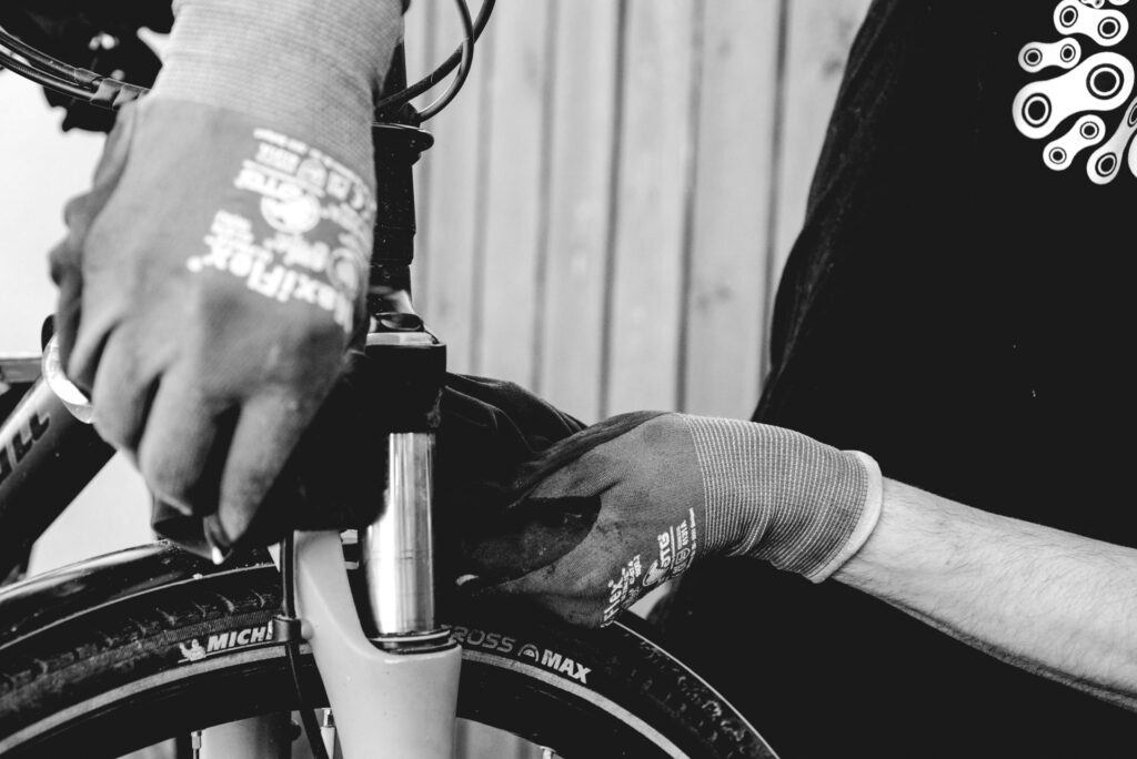 Reinigung einer Fahrradfedergabel mit Handschuhen für optimale Pflege und Langlebigkeit.