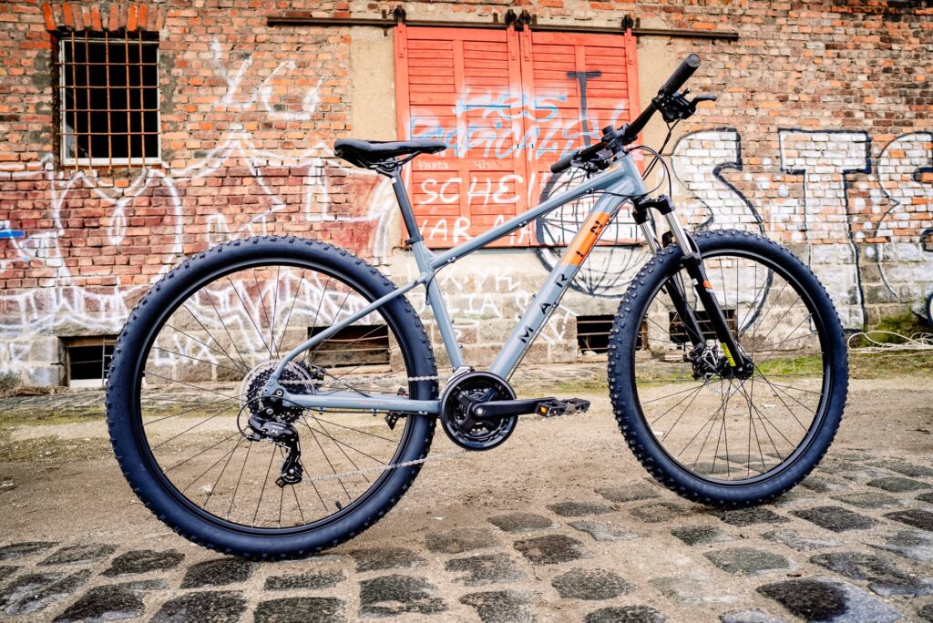 Marin Bolinas Ridge 1 Mountainbike vor urbaner Graffiti-Wand, robustes Design, ideal für Offroad-Abenteuer.