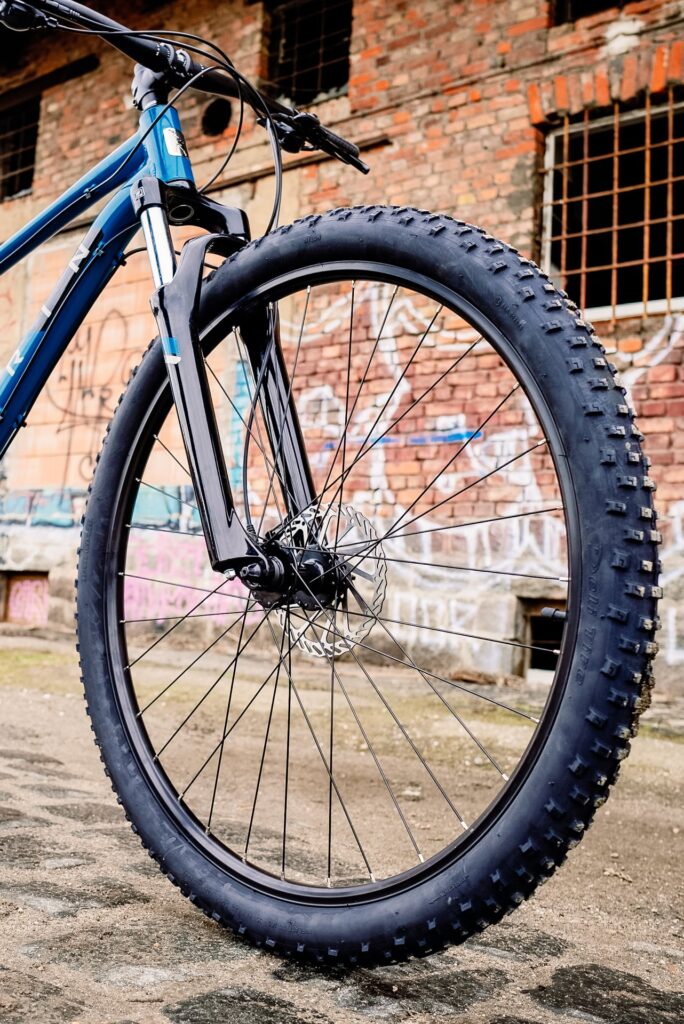 Vorderrad des Marin Bolinas Ridge 2 mit Scheibenbremse vor urbaner Backsteinwand.