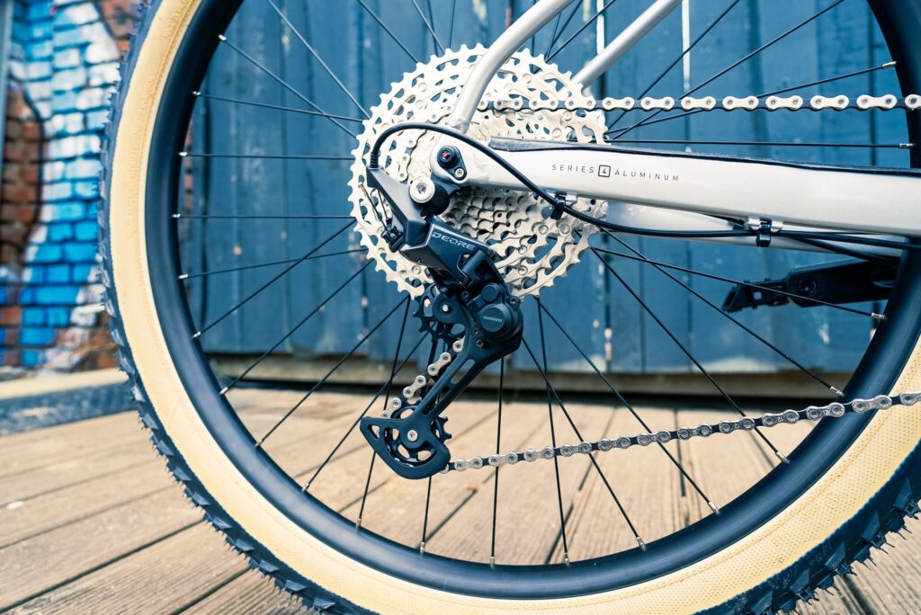 Shimano Deore 1x12 Schaltung am Marin Team Marin 1 2023, Nahaufnahme des Hinterrads auf Holzuntergrund.