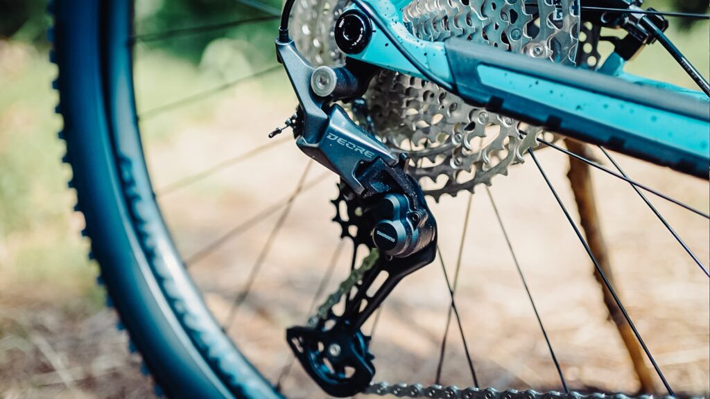 Shimano Deore Schaltwerk am Trek Roscoe 7 2023, Nahaufnahme des Hinterrads mit Fokus auf die Gangschaltung.