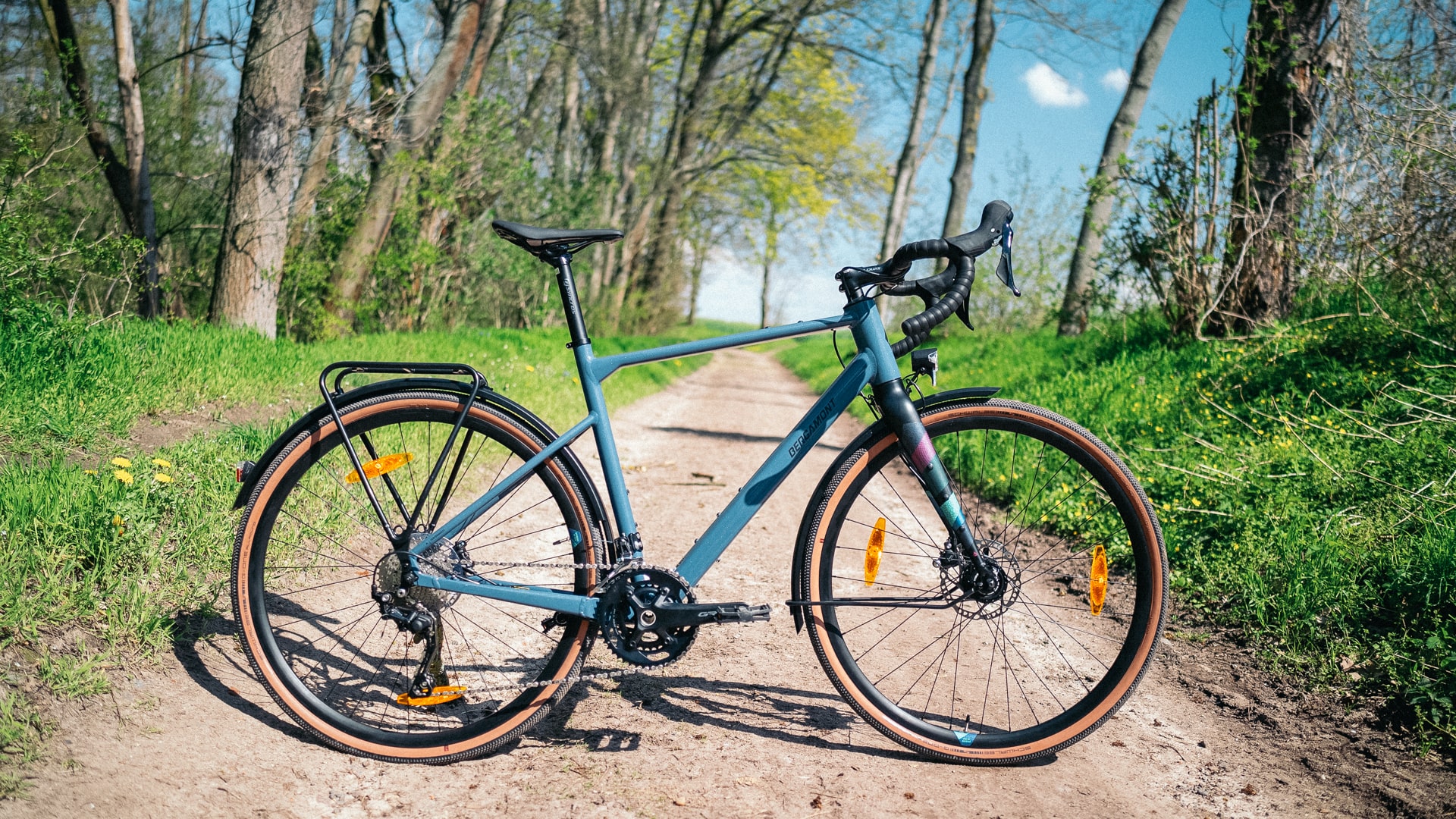 Bergamont Grandurance RD 5 2023 auf Waldweg, umgeben von grüner Natur, ideal für Offroad-Abenteuer.