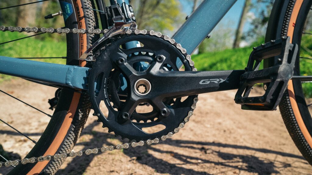 Kurbeldetail des Bergamont Grandurance RD 5 2023 mit Shimano GRX-Antrieb auf Schotterweg.