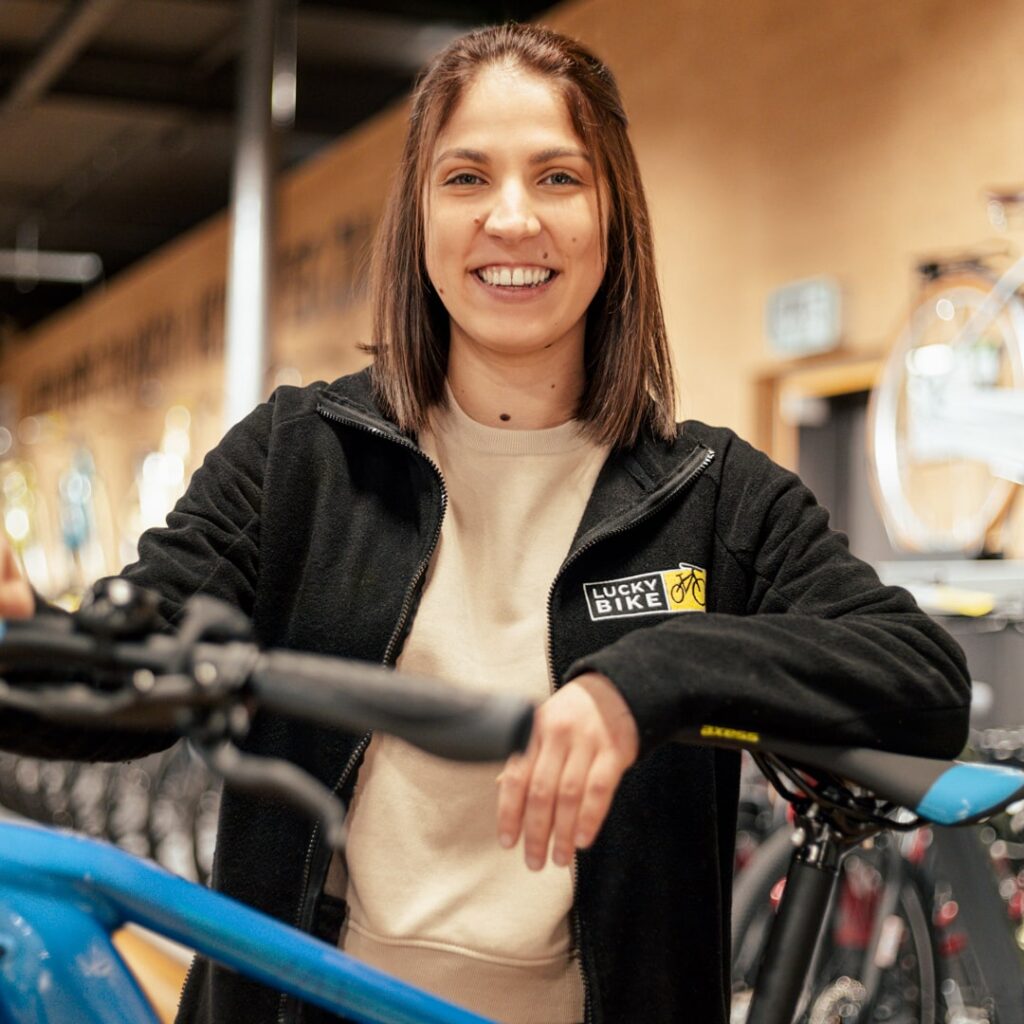 Mitarbeiterin mit E-Mountainbike im Fahrradgeschäft