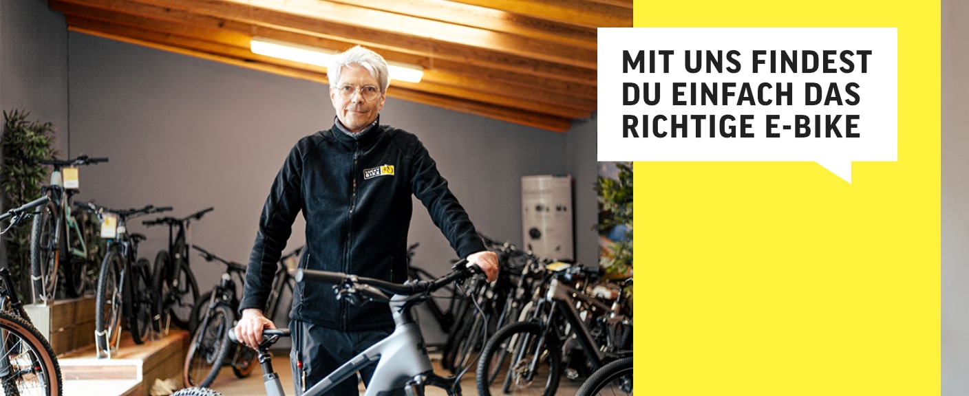 Mitarbeiterin von Lucky Bike berät beim Kauf; "Mit uns findest du einfach das richtige E-Bike" auf gelbem Hintergrund.