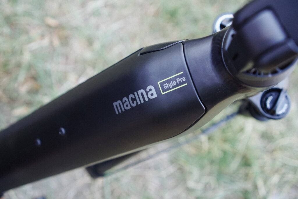 KTM Macina Style Pro 2024 Nahaufnahme des Rahmendesigns mit Logo, elegantes E-Bike-Design auf Gras.