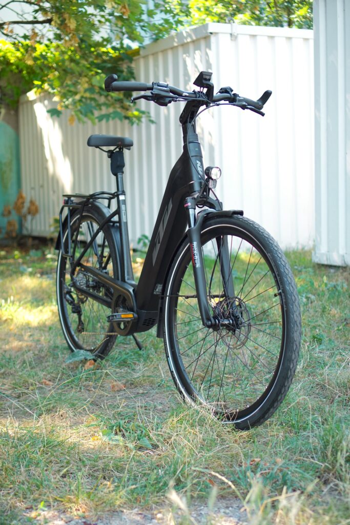 KTM Macina Style Pro 2024 E-Bike im Grünen, seitliche Frontansicht, modernes Design, robuste Ausstattung.