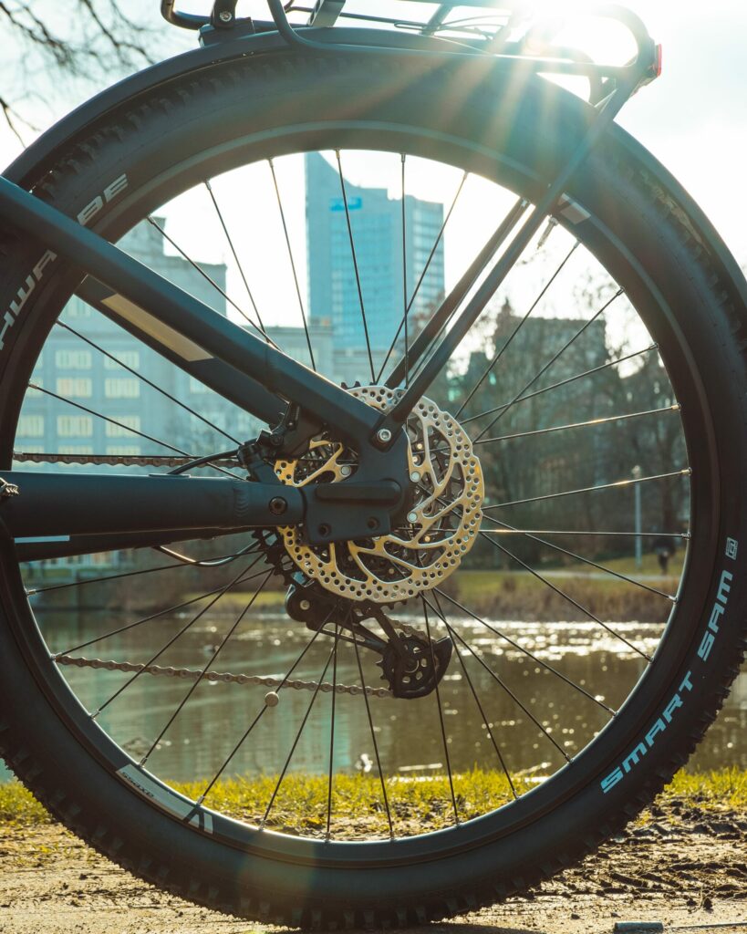 Hinterradbremse des Axess Rogue FS Allroad 2024 vor städtischer Kulisse bei Sonnenschein.