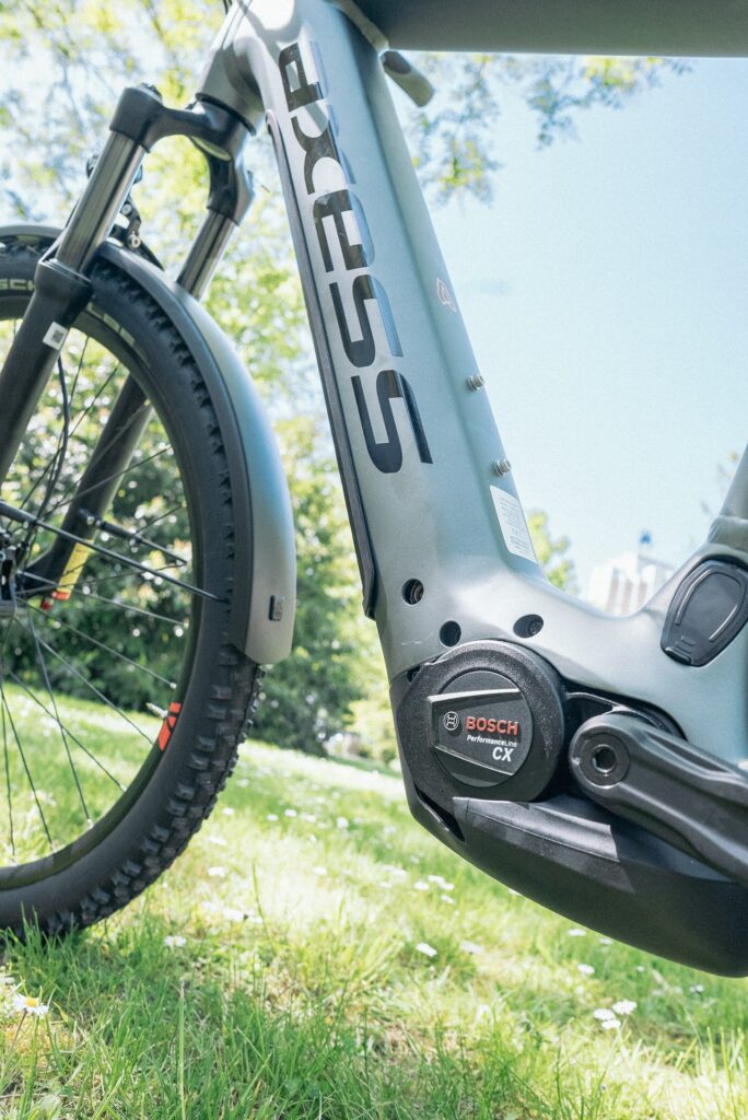 Axess Force Pro Allroad E-Bike mit Bosch Performance Line CX Motor auf grünem Rasen im Sonnenlicht.