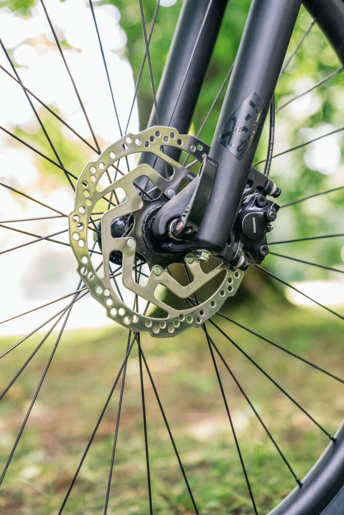 Shimano MT200 Bremse am Scott Scale 980 2024, Nahaufnahme im Grünen.