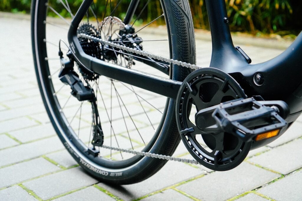 Antrieb des Cube Editor Hybrid Pro 400X, Nahaufnahme der Kette und Pedale auf gepflastertem Untergrund.