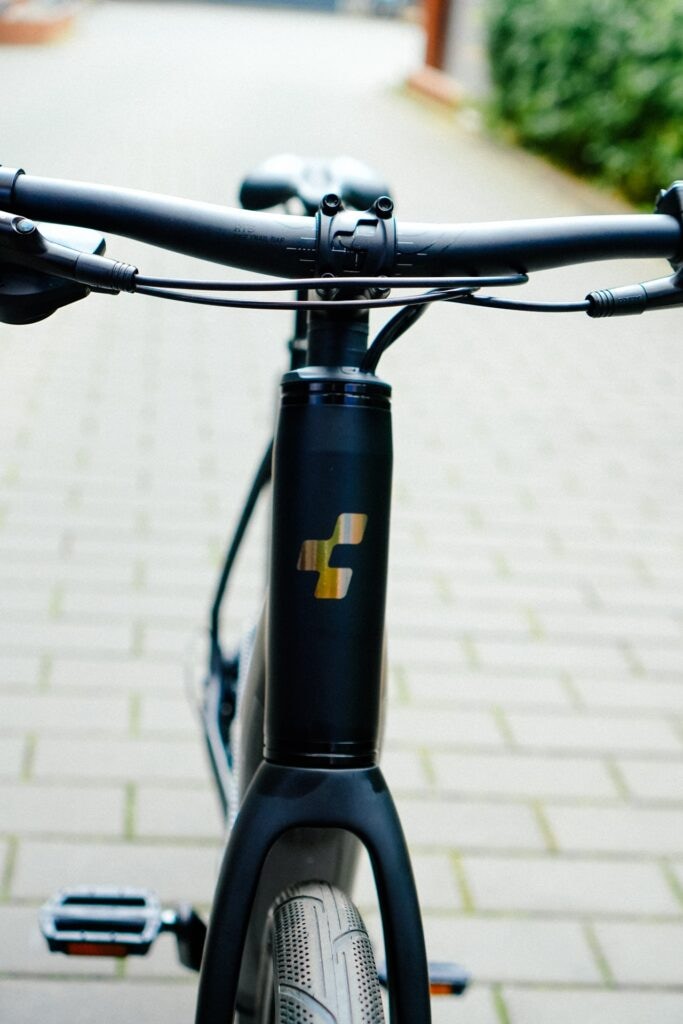 Cube Editor Hybrid Pro 400X Lenker und Vorderrad auf gepflastertem Weg, modernes Design, Nahaufnahme.