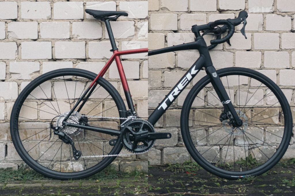 Trek Émonda ALR 5 und Domane AL 5 nebeneinander vor Ziegelwand, Fokus auf Rahmen und Räder.