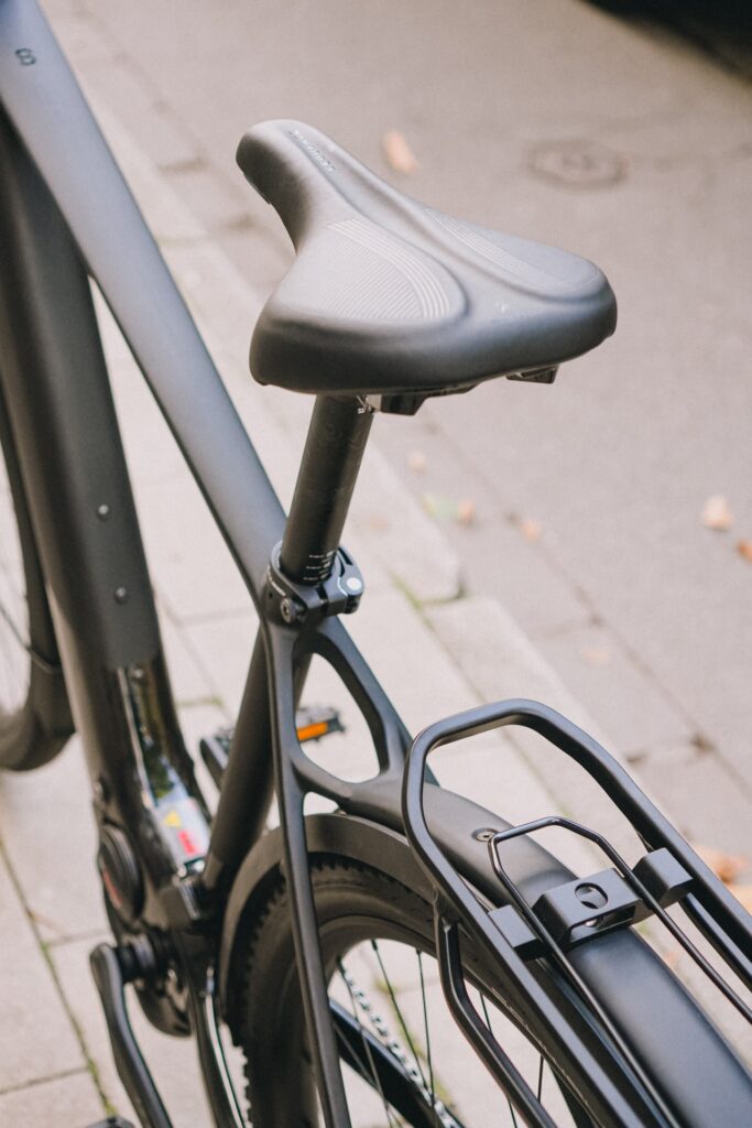 Detailansicht des Sattels und Gepäckträgers des Cube Kathmandu Hybrid C:62 SLX 2025 auf Gehweg.