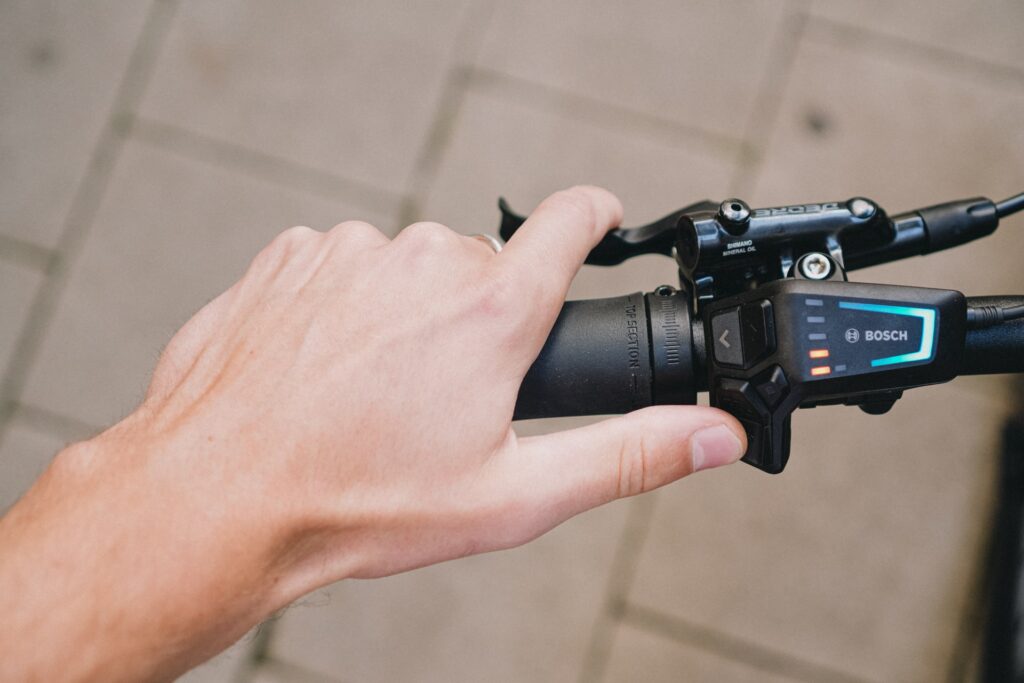 Hand bedient Bosch-Display am Lenker eines Cube Kathmandu Hybrid E-Bikes, Detailansicht der Steuerung.