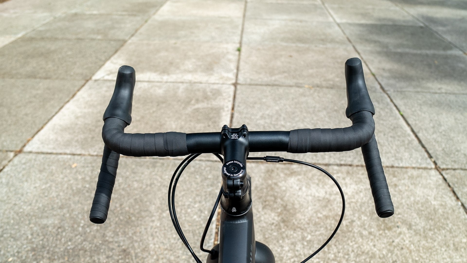 Gravelbike-Lenker auf Asphalt, Fokus auf ergonomisches Design und Kontrolle für verschiedene Preisklassen.