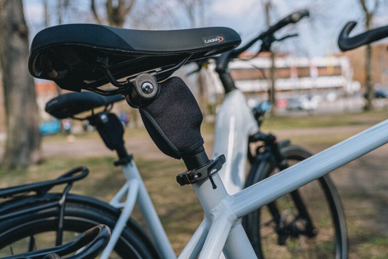 Nahaufnahme eines weißen E-Bike-Sattels und Rahmens im Freien, Fokus auf Details und Design.
