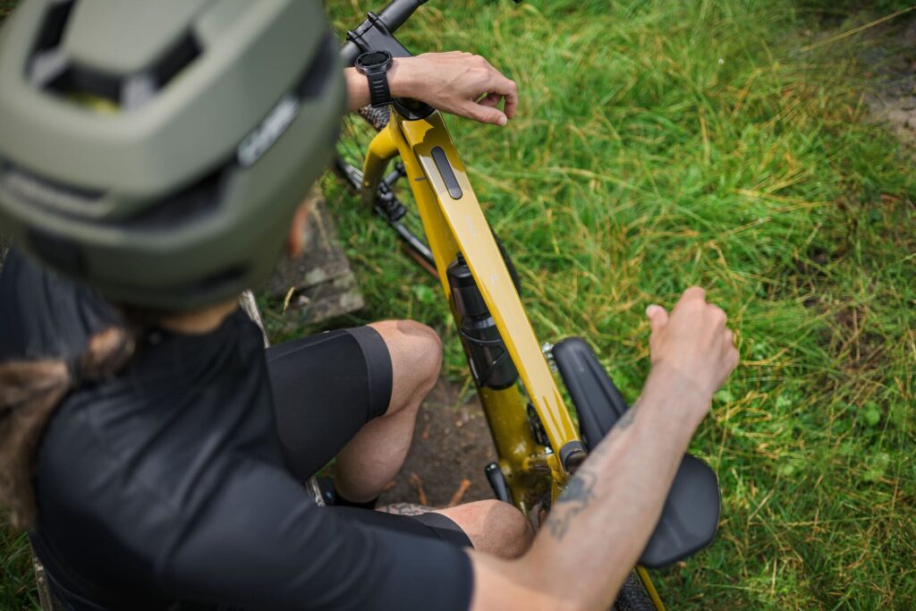 Radfahrer auf gelbem Cube Nuroad C:62, Fokus auf Oberrohr und Lenker, im Grünen unterwegs.