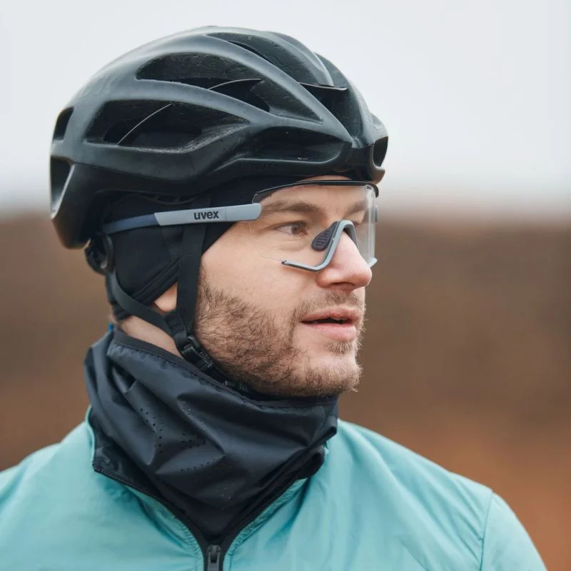Radfahrer mit schwarzem Helm, Sportbrille und türkisem Trikot in Nahaufnahme