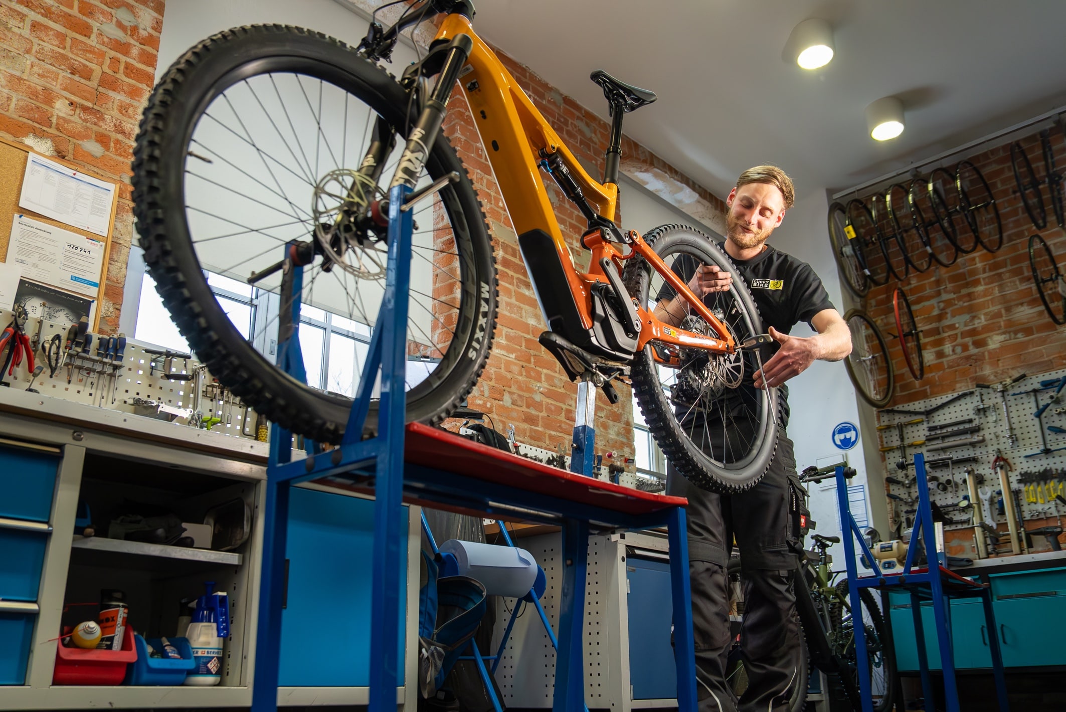 Mitarbeiter von Lucky Bike arbeitet an einem Fahrrad in einer Werkstatt