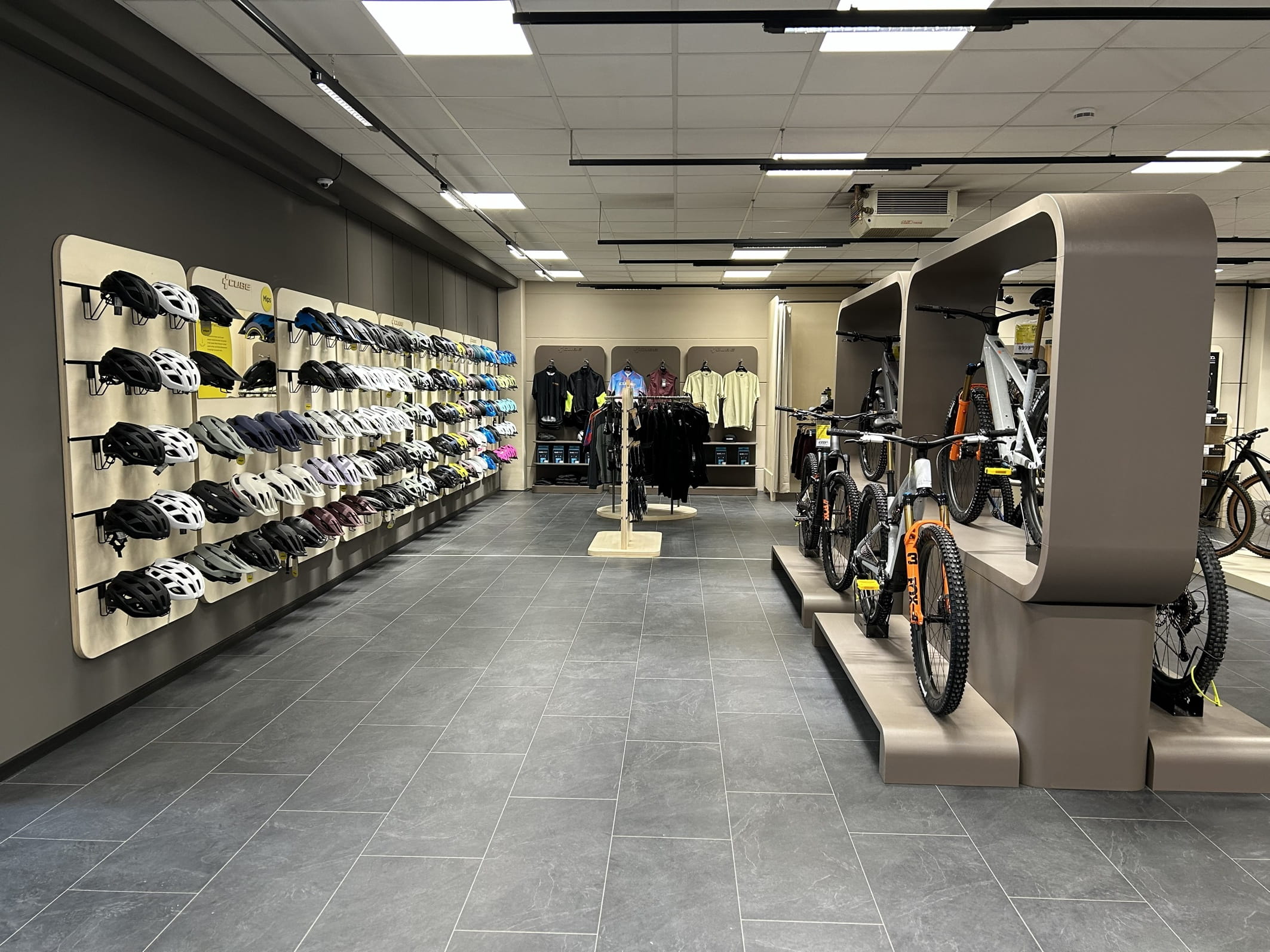 Innenansicht des neuen Cube Stores Günzburg powered by Lucky Bike mit Blick auf paar Fahrräder sowie Fahrradhelme