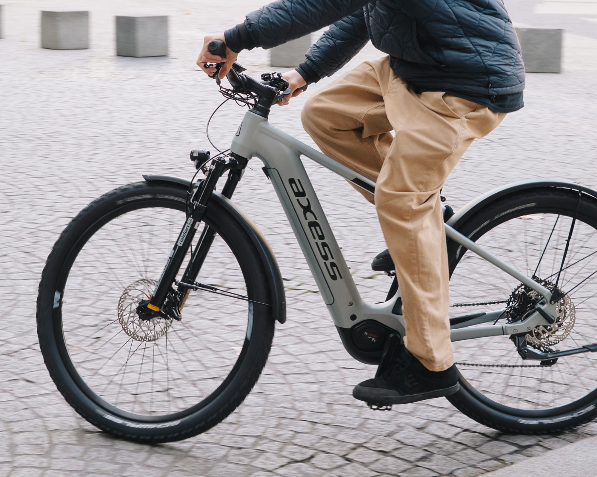 Eine Nahaufnahme einer fahrradfahrenden Person auf einem E-Bike im urbanen Raum